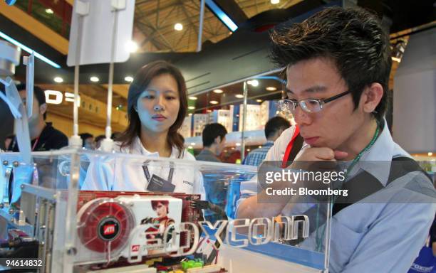 Visitors look at the motherboards within Intel 975X chipset at the Foxconn booth at Computex Technology fair, in Taipei, Taiwan, June 8, 2006.