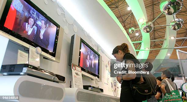Visitors look at Idea 500 multimedia PCs and LCD TVs at the Acer booth at Computex Technology fair, in Taipei, Taiwan, June 8, 2006.