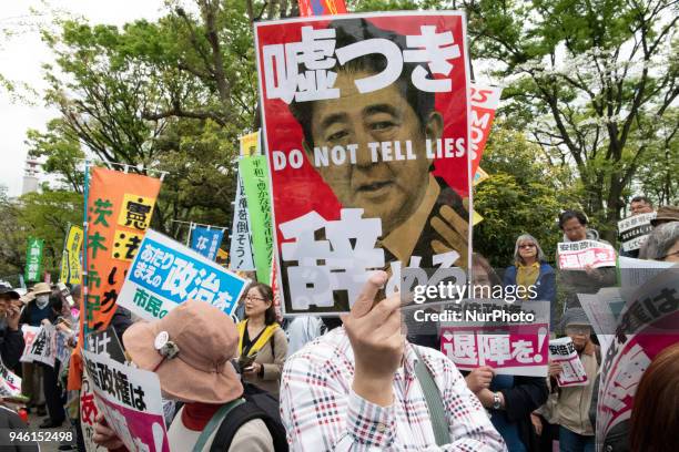 Protester holds a placard during a demonstration against Japan's Prime Minister Shinzo Abe after allegations of corruption, calling him to resign, on...