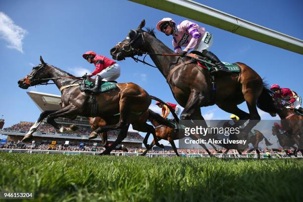 Horses and riders pass the grandstand during the first race the Gaskells Handicap Hurdle Race at Aintree Racecourse on April 14, 2018 in Liverpool,...