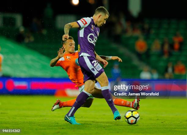 Scott Neville of the Perth Glory pass the ball away while under pressure from Eric Bautheac of the Brisbane Roar during the round 27 A-League match...