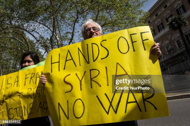 Protester holds a placard during a demonstration against the military action in Syria in front of the US embassy in Rome, Italy, 14 April 2018. USA,...