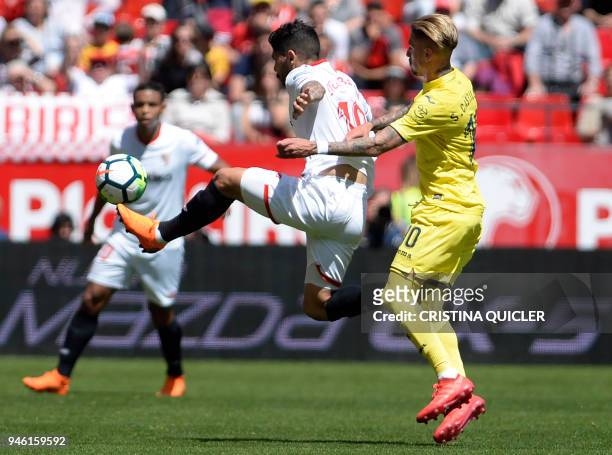 Sevilla's Argentinian midfielder Ever Banega jumps for the ball beside Villarreal's Spanish midfielder Samuel Castillejo Azuaga during the Spanish...