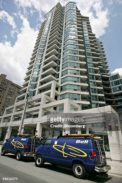 Two Bell vehicles, a brand of BCE Inc., sit outside a condominium tower in Toronto, Canada, Thursday, June 21, 2007. Shares of BCE Inc. Rose as much...