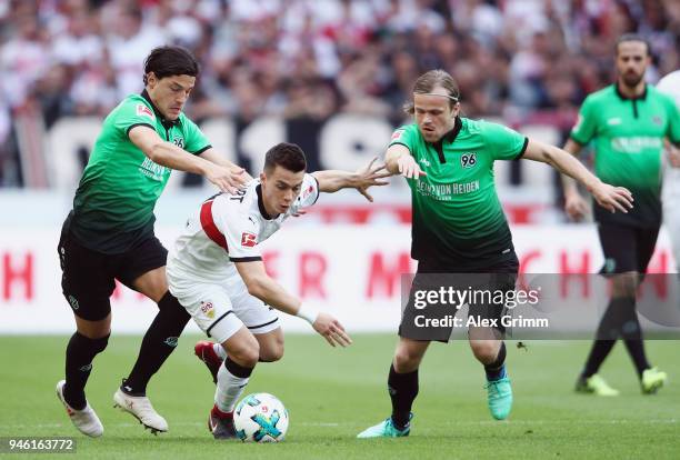 Erik Thommy of Stuttgart is challenged by Miiko Albornoz and Iver Fossum of Hannover during the Bundesliga match between VfB Stuttgart and Hannover...