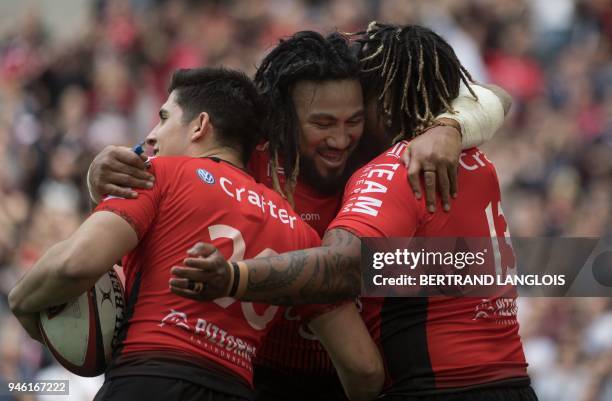 Toulon's French centre Mathieu Bastareaud is congratulated by RC Toulon's French flyhalf Anthony Belleau and RC Toulon's New Zealander centre Maa...