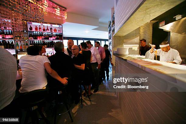 Patrons sit at the bar while watching a sous chef prepare a dish through the semi open kitchen at Centro I Vinoteca, an Italian bistro in the West...