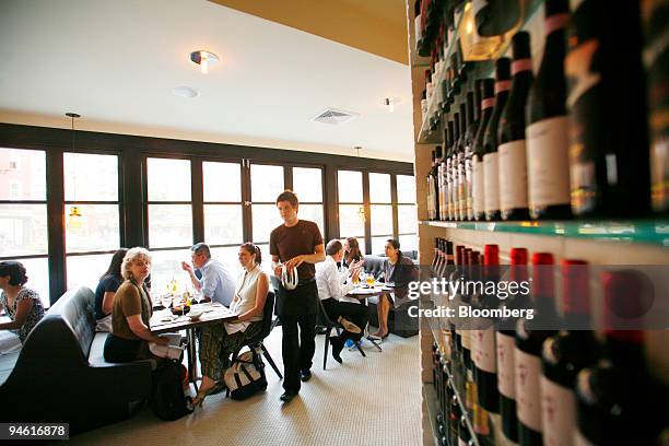 Waiter refills water while patrons dine at Centro I Vinoteca, an Italian bistro in the West Village neighborhood of New York, on Aug. 2, 2007.