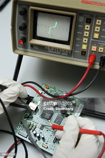 Technician checks the circuit board of a Canon digital photo printer at Canon in Petaling Jaya, Malaysia, on Monday, Jan. 7, 2008. Malaysia's export...