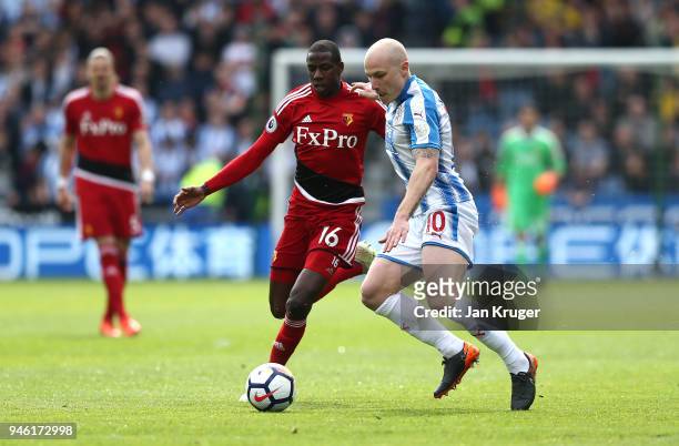Aaron Mooy of Huddersfield Town is challenged by Abdoulaye Doucoure of Watford during the Premier League match between Huddersfield Town and Watford...