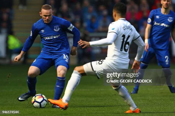 Everton's English striker Wayne Rooney vies with Swansea City's Swedish defender Martin Olsson during the English Premier League football match...