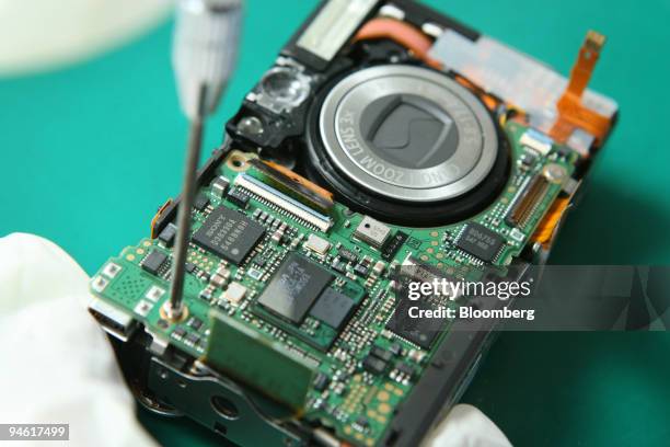 Electronic chips are installed in a compact digital camera at Canon in Petaling Jaya, Malaysia, on Monday, Jan. 7, 2008. Malaysia's export growth...