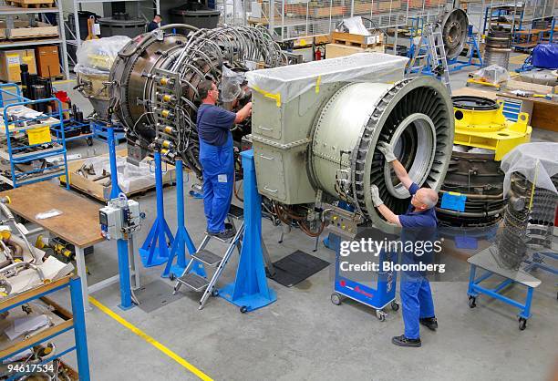 Workers assemble an aircraft jet engine at the MTU Aero engines factory in Ludwigsfelde, Germany, Wednesday, August 23, 2006.