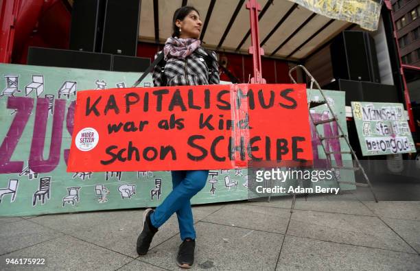 Participant with sign reading 'Capitalism Was Already Shit When It Was A Child' demonstrates against rent increases and gentrification, at Potsdamer...