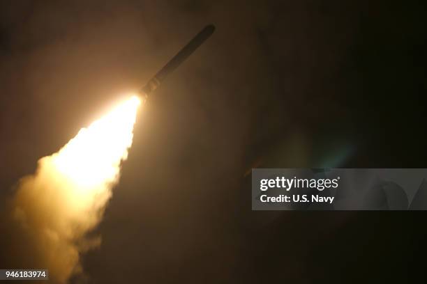 In this handout released by the U.S. Navy, the guided-missile cruiser USS Monterey fires a Tomahawk land attack missile at Syria as part of an allied...