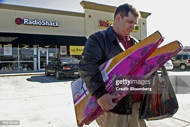 Jimmy Scheirer, manager of a local bowling alley, leaves a RadioShack store, in Bossier City, Louisiana, with an arm full of items he intends to use...