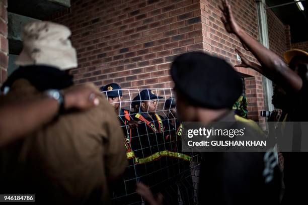 South African Police prevent mourners from entering the stands at the full to capacity Orlando Stadium in the township of Soweto during the funeral...