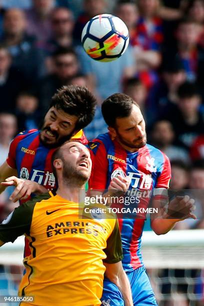 Crystal Palace's English defender James Tomkins and Crystal Palace's Serbian midfielder Luka Milivojevic go up against Brighton's English striker...