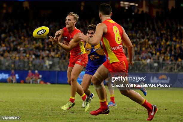 Darcy MacPherson of the Suns handpasses the ball during the round four AFL match between the West Coast Eagles and the Gold Coast Suns at Optus...