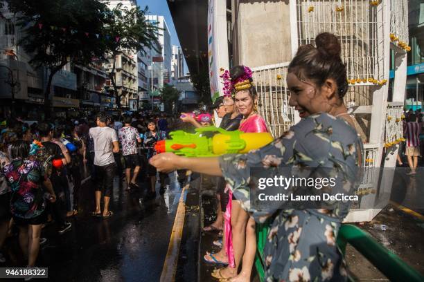 Thai ladyboys spray water guns during the Songkran celebration party on Silom Road on April 14, 2018 in Bangkok, Thailand. Songkran is the Thai new...