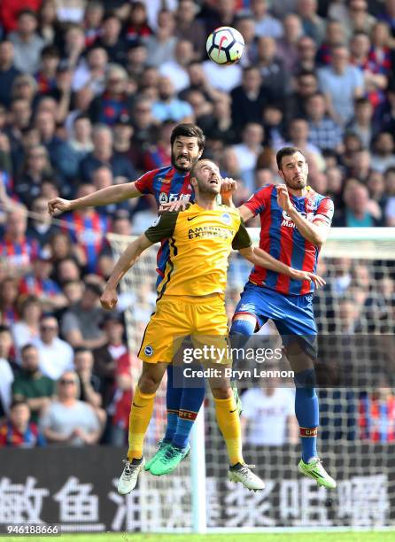 James Tomkins of Crystal Palace, Glenn Murray of Brighton and Hove Albion, and Luka Milivojevic of Crystal Palace compete for a header during the...