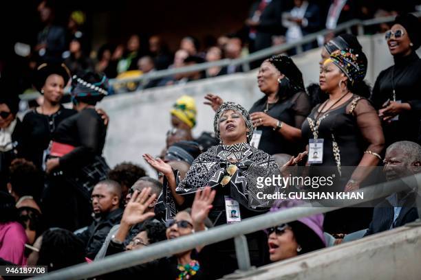 Mourners react from the stands of the full 37,500-seater Orlando Stadium in the township of Soweto during the funeral of the late anti-apartheid...