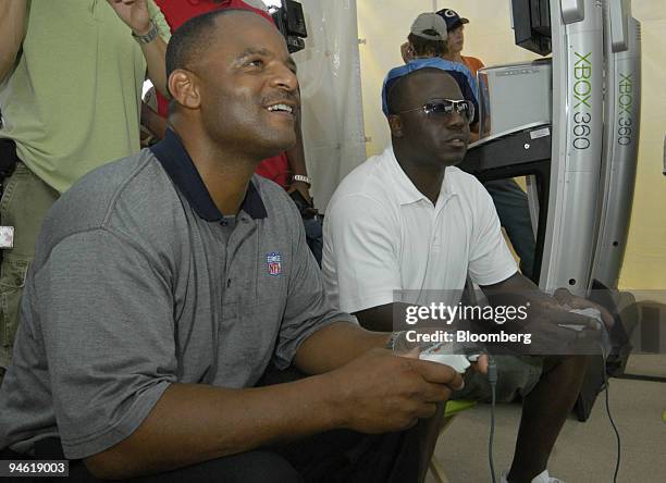 Warren Moon, left, former quarterback for the Kansas City Chiefs, plays Marshall Faulk, running back for the St. Louis Rams, in Electronic Arts...