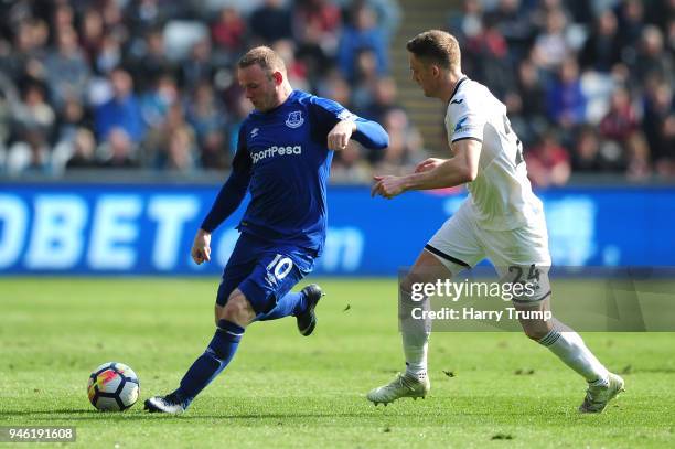 Wayne Rooney of Everton is challenged by Andy King of Swansea City during the Premier League match between Swansea City and Everton at Liberty...