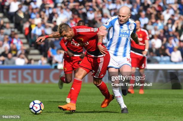 Roberto Pereyra of Watford is challenged by Aaron Mooy of Huddersfield Town during the Premier League match between Huddersfield Town and Watford at...