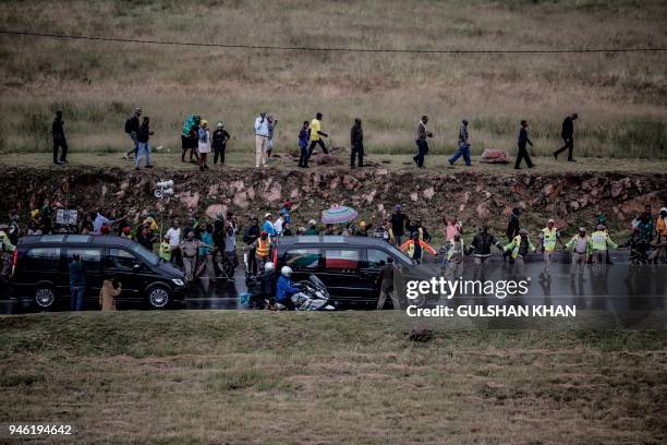 Residents of Soweto run up the banks to get a glimpse of the casket of the late anti-Apartheid champion Winnie Madikizela Mandela as it leaves the...