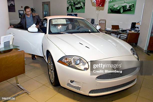 Robert Wright, left, gets into the passenger seat of a Jaguar while car shopping with Katalin Lax, in driver's seat, at a dealership in New York,...