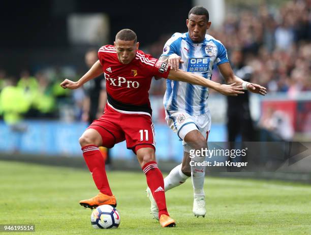 Richarlison de Andrade of Watford is challenged by Rajiv van La Parra of Huddersfield Town during the Premier League match between Huddersfield Town...
