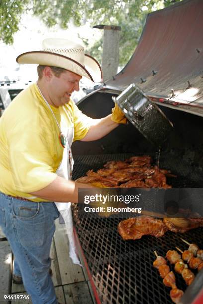 Barrett Chobelas of Seaton adds juices to his cooking goat meat during the 34th annual world championship goat cook-off in Brady, Texas, U.S., on...