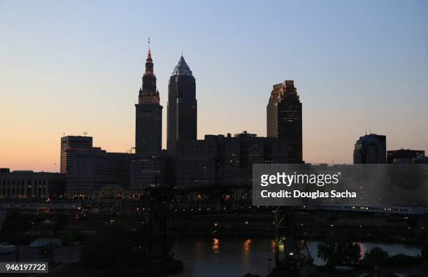 silhouette of a city skyline - cleveland ohio flats stock pictures, royalty-free photos & images