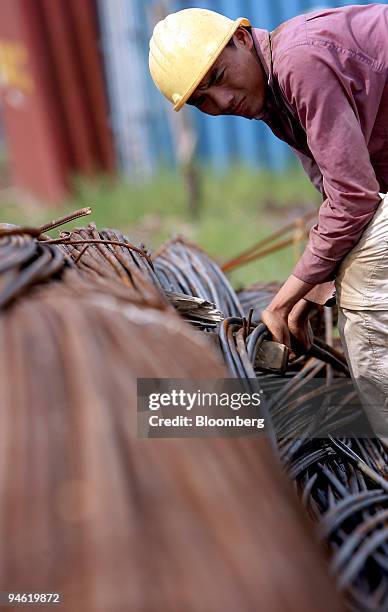 Construction worker looks over steel rods on a building site in Hanoi, Vietnam on Sunday, August 20, 2006.