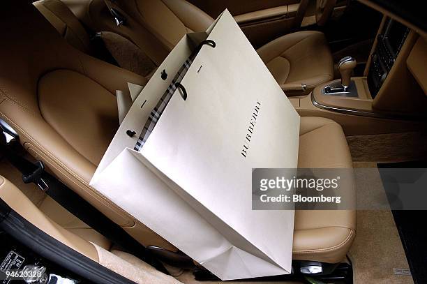 Burberry shopping bag sits inside a Porsche automobile on via Montenapoleone in Milan, Italy, Sunday, January 7, 2007.