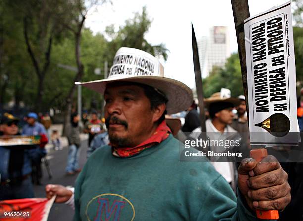 Demonstrator holds a machete with a sticker that reads "National movement to defend the oil" during a rally with Mexican farmers against the North...