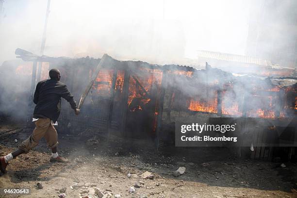 Buildings burn as supporters of Raila Odinga, the opposition presidential candidate protest on the streets of Nairobi, Kenya, on Wednesday, Jan. 2,...