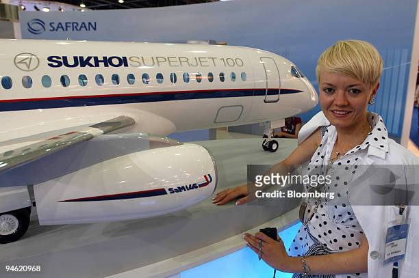 Yulia Makarova poses with the model of a Sukhoi SuperJet-100 at the Sukhoi stand during the 47th International Paris Air Show in Le Bourget, France,...