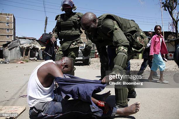 Members of the security forces help a wounded man during protests by supporters of Raila Odinga, the opposition presidential candidate in Nairobi,...