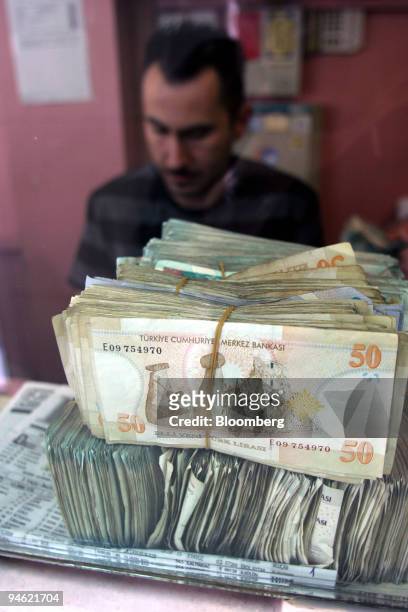 Worker at a currency exchange shop counts stacks of Turkish lira in the Taksim district of Istanbul, Turkey, Monday, April 30, 2007. For proof that...