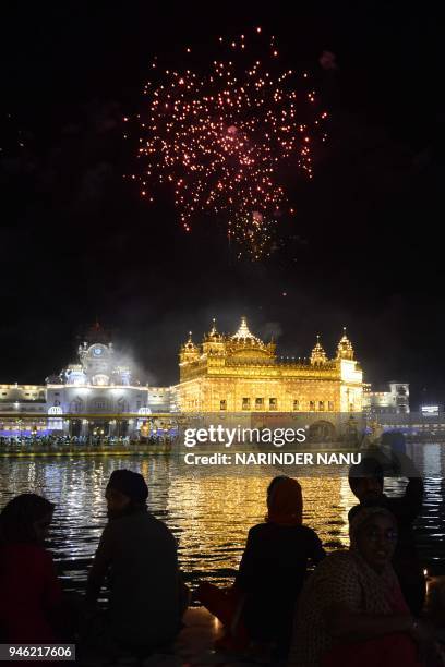 Indian Sikh devotees watch fireworks for the Baisakhi festival, which marks the new year for the Sikh community, at the Golden Temple in Amritsar on...