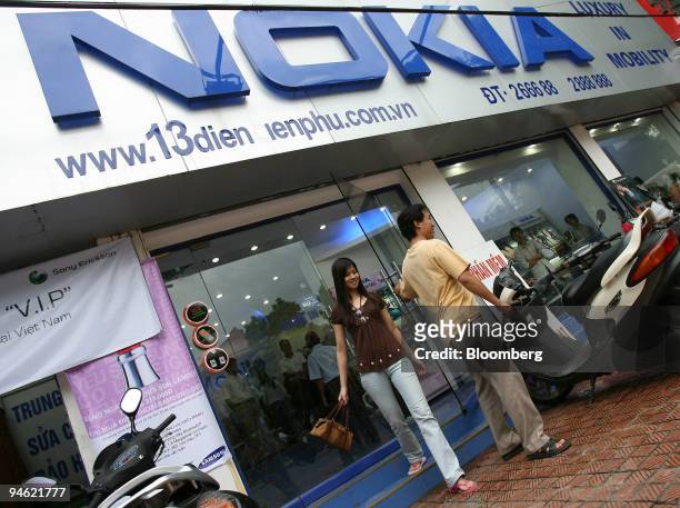 Young couple leave a Nokia shop in downtown Hanoi, Vietnam on Sunday, August 20, 2006.