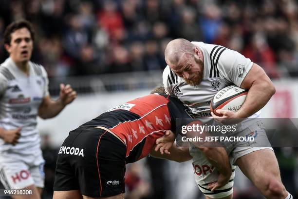 Brive's French prop Vivien Devisme is tackled by Oyonnax' Australian lock Phoenix Battye during the French Top 14 rugby union match US Oyonnax vs CA...