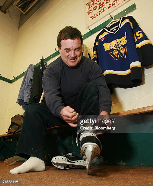 Canadian Finance Minister Jim Flaherty laces up his ice skates before a news conference to promote the Children's Fitness Tax Credit in Whitey,...