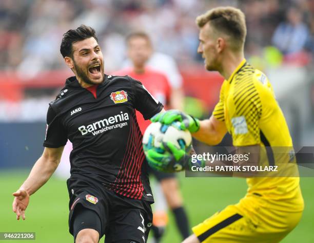Leverkusen's German forward Kevin Volland and Frankfurt's Finnish goalkeeper Lukas Hradecky vie for the ball during the German first division...