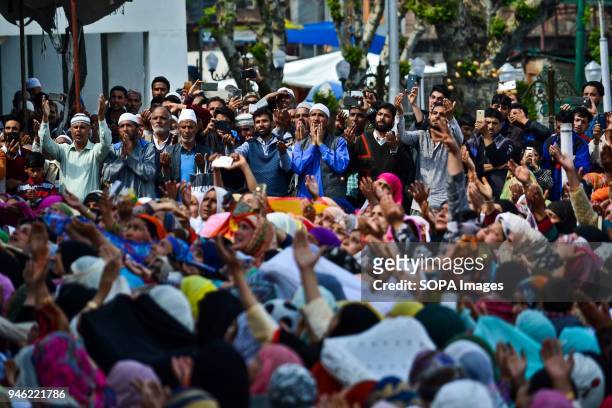 Kashmiri Muslims raise their hands in prayer on seeing a relic beleived to be hair from the beard of Prophet Muhammad on the occasion of the Islamic...