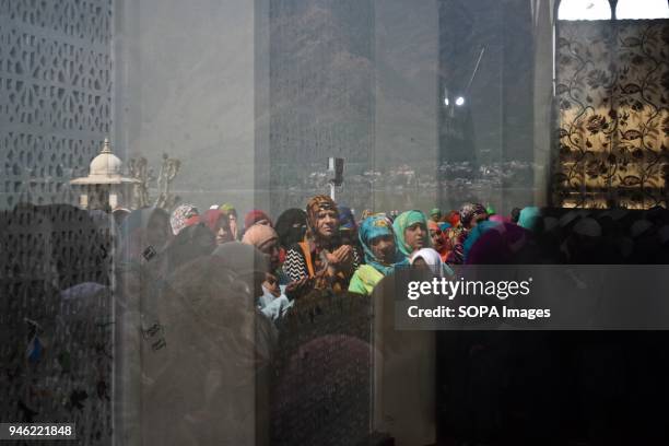 Kashmiri woman is reflected in a mirror as she prays on the occasion of the Islamic festival Shab-e-Meraj at Hazratbal Shrine in Srinagar, Indian...