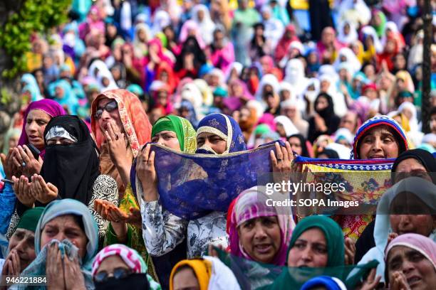 Kashmiri Muslim women pray upon seeing a relic believed to be hair from the beard of Prophet Muhammad on the occasion of the Islamic festival...