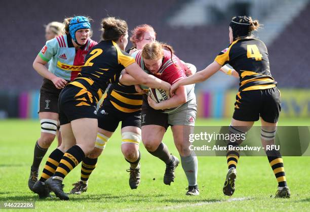 Chloe Edwards of Harlequins Ladies is tackled by Amy Cokayne and Alice Sheffield of Wasps FC Ladies during the Premier 15s Semi Final 2nd Leg between...